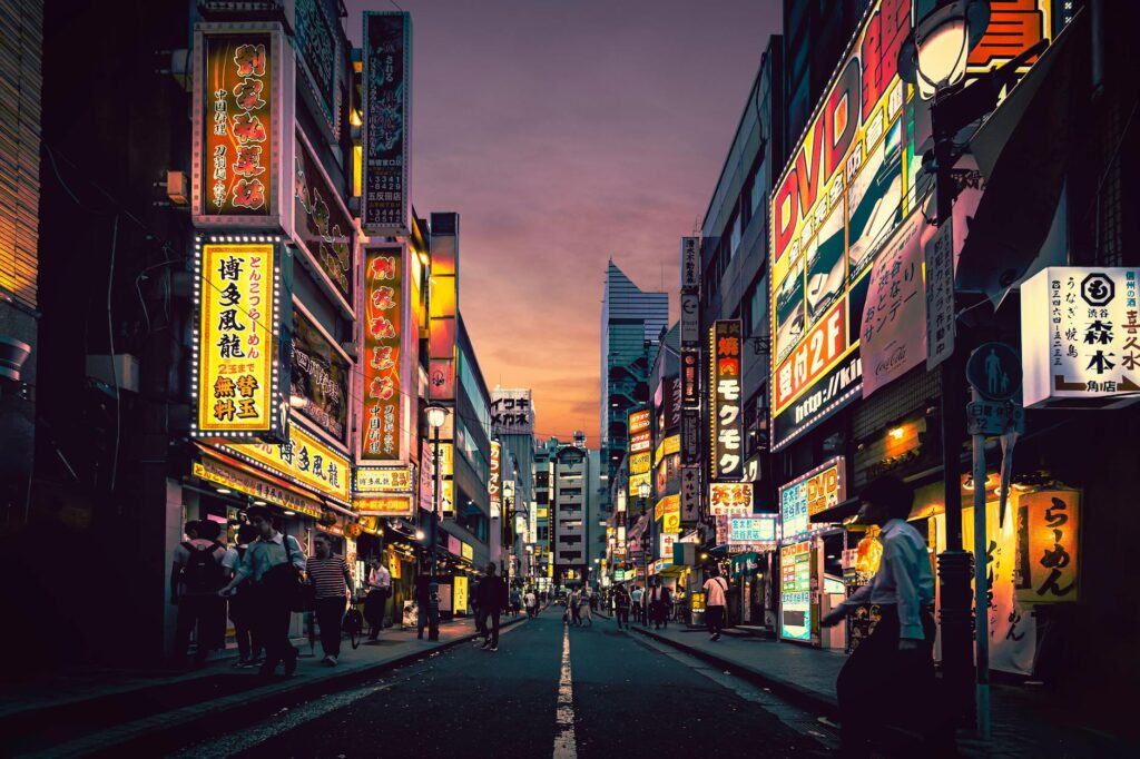 Explore the vibrant nightlife of Shibuya, Tokyo, showcasing neon-lit streets bustling with activity after sunset.